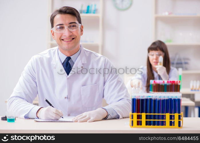 Two chemists working in lab experimenting