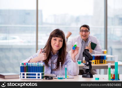 Two chemists working in lab experimenting