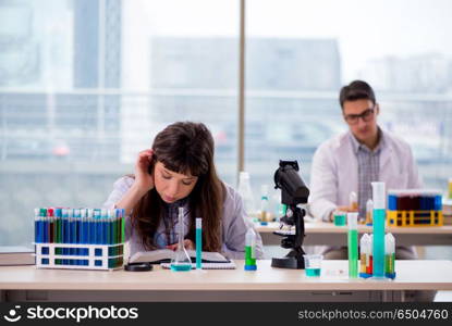 Two chemists working in lab experimenting