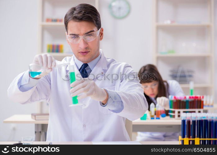 Two chemists working in lab experimenting