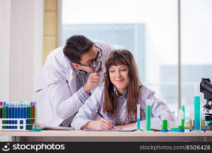 Two chemists working in lab experimenting