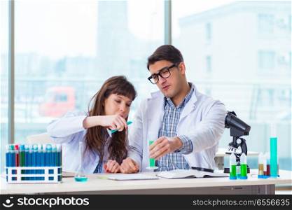 Two chemists working in lab experimenting