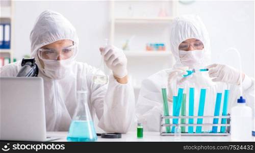 Two chemists working in the lab. The two chemists working in the lab