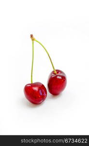 Two cherries on white background