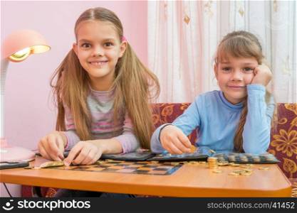 Two children are considered a collection of coins in albums