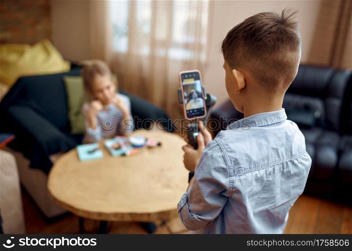 Two children bloggers records blog on camera, little vloggers. Kids blogging in home studio, social media for young audience, online internet broadcast. Two children bloggers records blog on camera