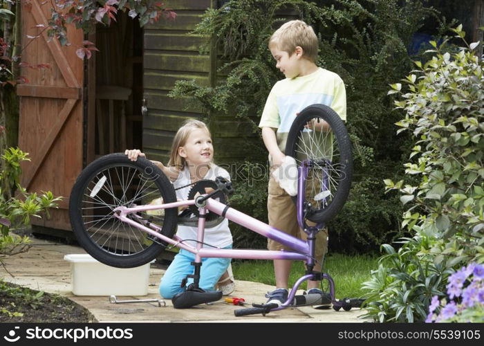 Two Children Cleaning Bike Together