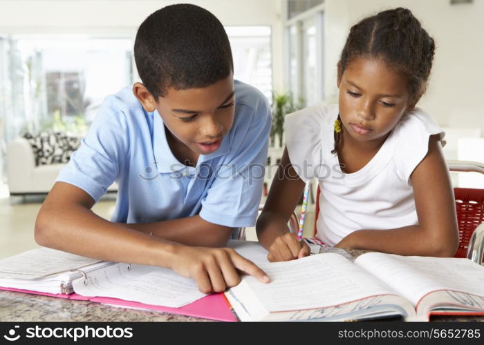 Two Children Doing Homework Together In Kitchen