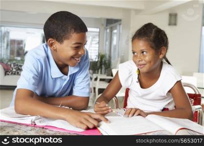 Two Children Doing Homework Together In Kitchen
