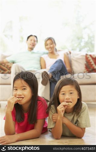 Two Children Eating Cookies At Home