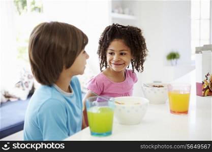 Two Children Having Breakfast In Kitchen Together