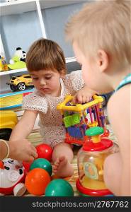 two children in playroom with plastic balls