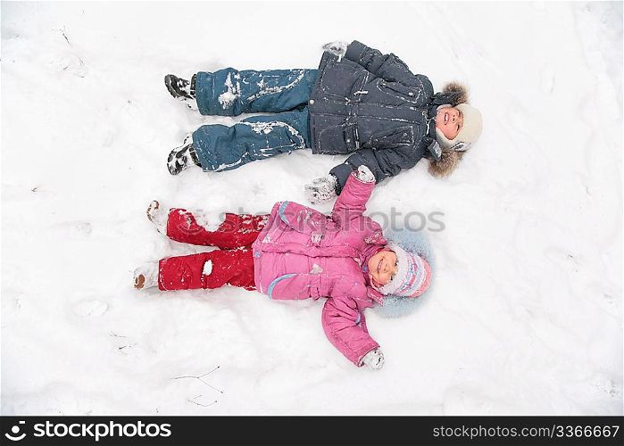 two children lie on snow