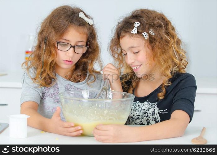 Two children mixing ingredients