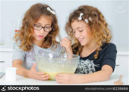Two children mixing ingredients