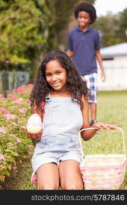 Two Children On Easter Egg Hunt In Garden