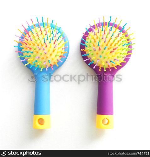 Two children's massage combs with curved multi-colored teeth. Isolate on white background.