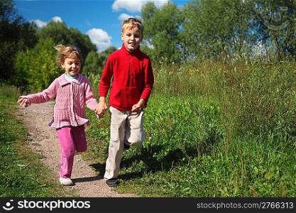 two children run on path in summer