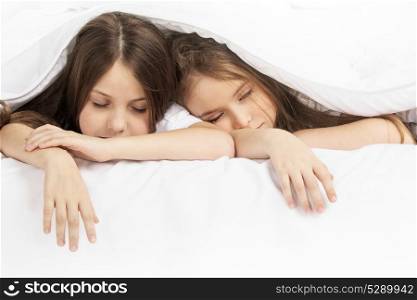 Two children sleeping in bed. Two beautiful children sleeping in bed under one white blanket
