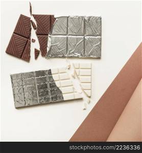 two chocolate bars silver foil against white background