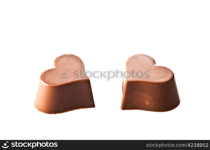 Two chocolate hearts over white background