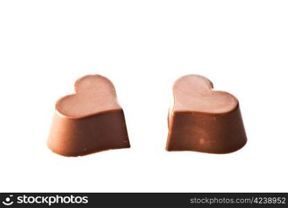 Two chocolate hearts over white background