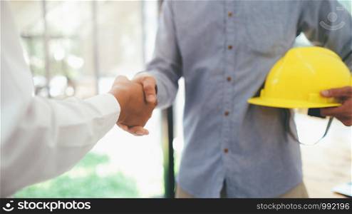 Two civil engineer or architect handshaking after have a good deal of mega project done. Engineer construction project concept.