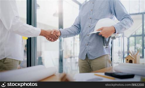 Two civil engineer or architect handshaking after have a good deal of mega project done. Engineer construction project concept.