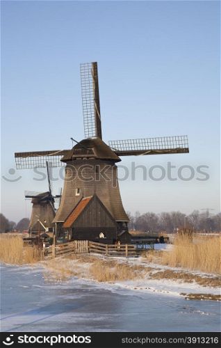Two classic windmills in winter with blue sky