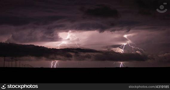 Two cloud-to-ground lightning bolts shoot through the low clouds of a supercell