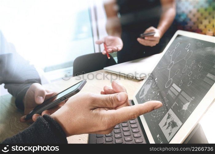 two colleague web designer discussing data and digital tablet docking keyboard and computer laptop with smart phone and design diagram on marble desk,sun light effect