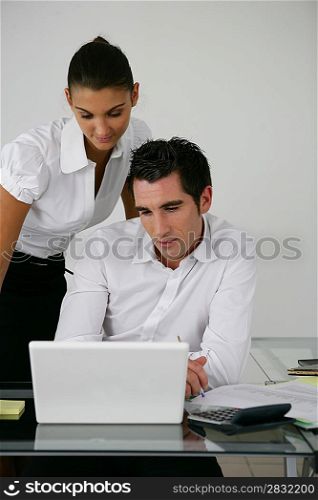 Two colleagues looking at laptop screen
