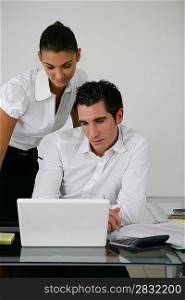 Two colleagues looking at laptop screen