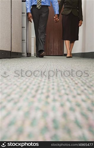 Two colleagues walking holding hands