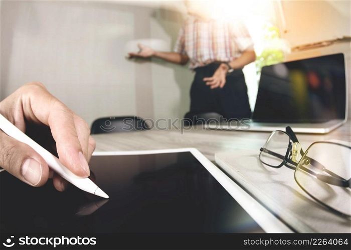 two colleagues web designer discussing data and blank screen digital tablet and computer laptop with smart phone on wooden desk as concept