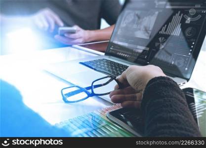 two colleagues website designer discussing data and digital tablet and computer laptop with graphics design diagram on marble desk as concept, sun flare effect  