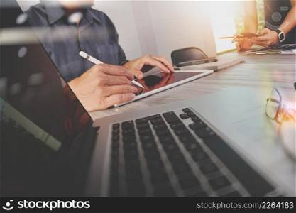 two colleagues Website designer working digital tablet and computer laptop with smart phone and digital design diagram on wooden desk as concept