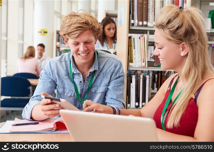 Two College Students Studying In Library Together