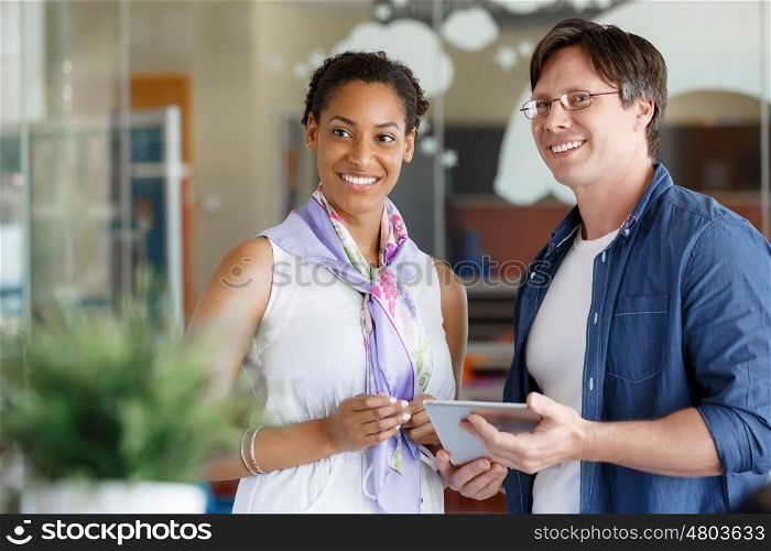Two collegues standing and discussing papers in a office