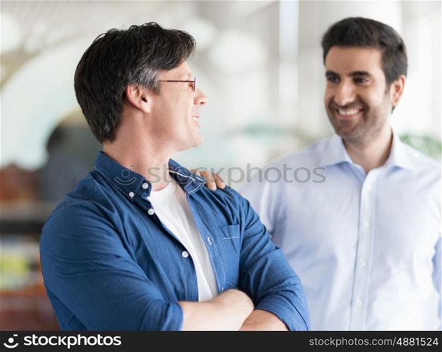 Two collegues standing and smiling happily