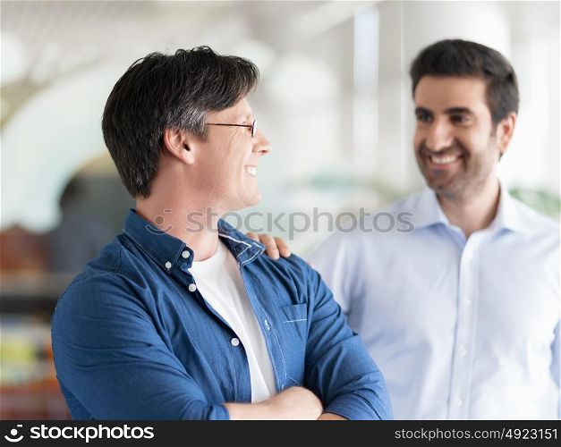 Two collegues standing and smiling happily