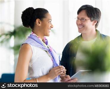 Two collegues standing next to each other in a office