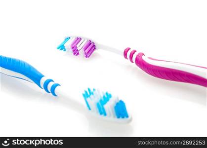 two color toothbrushes. Focused on reb toothbrush