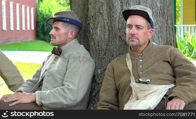 Two confederate Civil War soldiers near tree