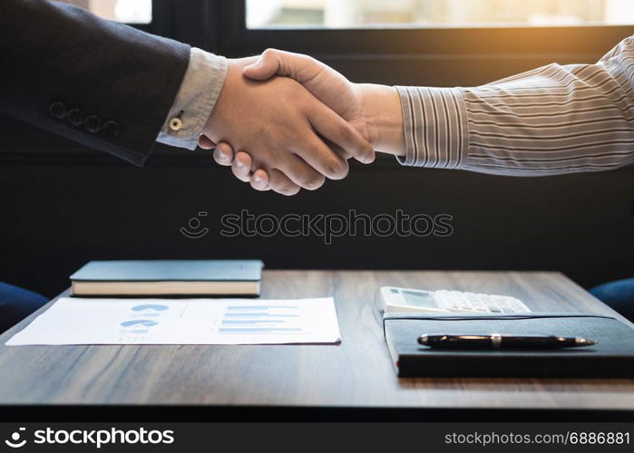 Two confident business man shaking hands during a meeting in the office, success, dealing, greeting and partner concept.