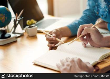 Two confident students doing homework together while sitting at the home or class room
