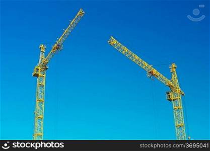 two construction cranes in sky
