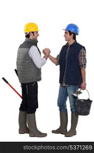 Two construction workers greeting each other