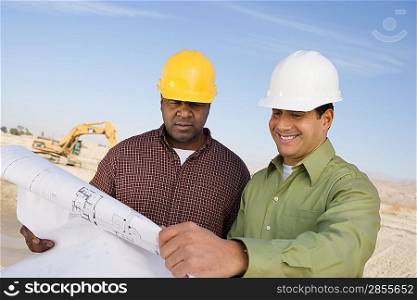 Two construction workers studying blueprint