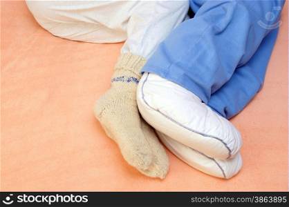 Two Couple&apos;s feet warming at a bed